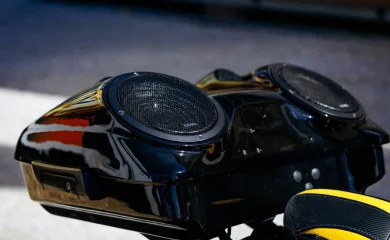 Glossy black motorcycle audio speaker pod with dual speakers.