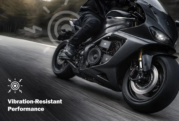 Black sport motorcycle in motion with integrated speaker components visible in the fairing. Text reads "Vibration Resistant Performance.