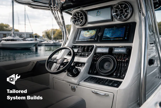 Boat helm with screens speakers and custom audio equipment integrated into the console. Text reads "Tailored System Builds."