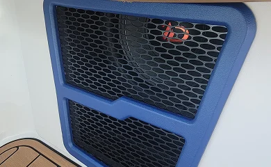 Blue custom speaker grille integrated into a vehicle panel.